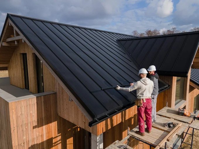 Roofers installing a standing seam metal roof on a home near Yucaipa, California.